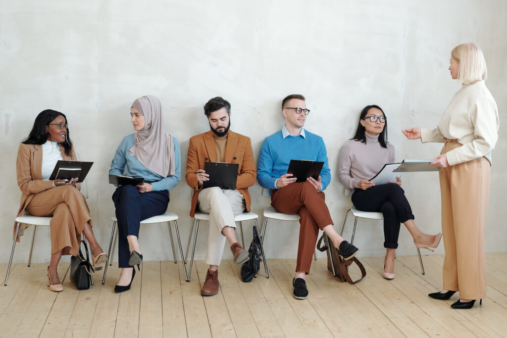 Groep werkzoekenden tijdens een sollicitatiegesprek, begeleid door een recruitmentmanager in Amsterdam, voor vacatures op wijwerken.nu.