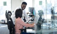 Samenwerken met Wijwerken.nu – Werk met aandacht voor mens en resultaat Twee collega’s overleggen op kantoor met een glimlach – symbool voor de persoonlijke begeleiding en samenwerking die Wijwerken.nu biedt aan werkzoekenden en werkgevers.